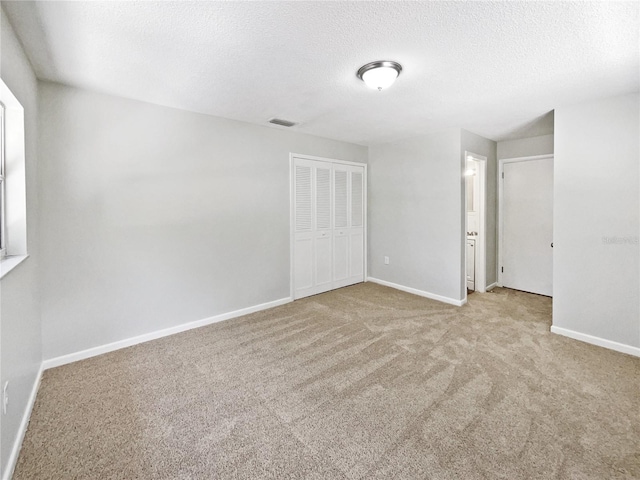 2607 Castle Oak Ave, Orlando, FL 32808 - unfurnished bedroom with carpet, a textured ceiling, and a closet