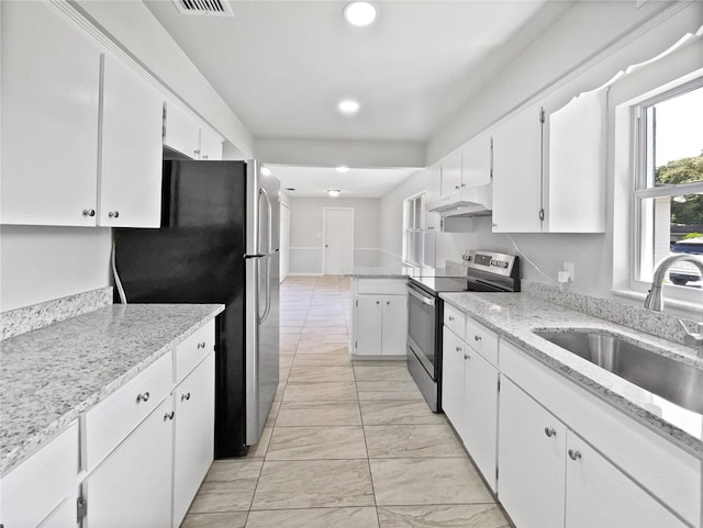 2607 Castle Oak Ave, Orlando, FL 32808 - kitchen with appliances with stainless steel finishes, under cabinet range hood, white cabinets, light marble finish flooring, and recessed lighting