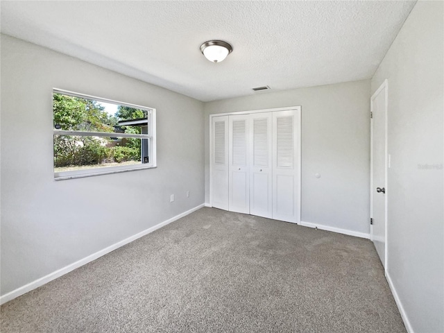 2607 Castle Oak Ave, Orlando, FL 32808 - unfurnished bedroom with carpet flooring, a closet, and a textured ceiling