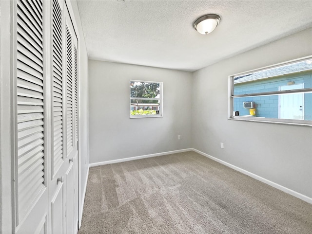 2607 Castle Oak Ave, Orlando, FL 32808 - unfurnished bedroom featuring a textured ceiling, a closet, and carpet flooring