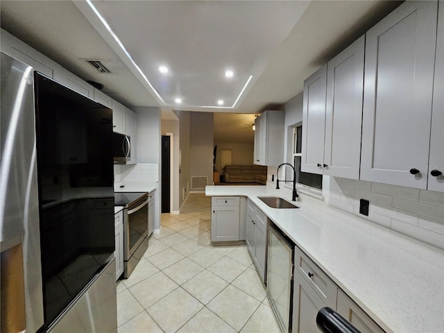2010 Appian Ct, Deltona, FL 32725 - kitchen with stainless steel appliances, decorative backsplash, light tile patterned floors, recessed lighting, and a peninsula