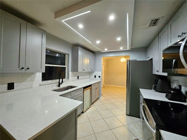2010 Appian Ct, Deltona, FL 32725 - kitchen with stainless steel microwave, dishwashing machine, backsplash, gray cabinets, and light tile patterned floors