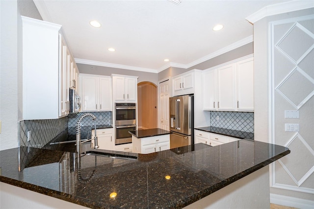 2258 Rickover Pl, Winter Garden, FL 34787 - kitchen with appliances with stainless steel finishes, decorative backsplash, arched walkways, dark stone countertops, and recessed lighting