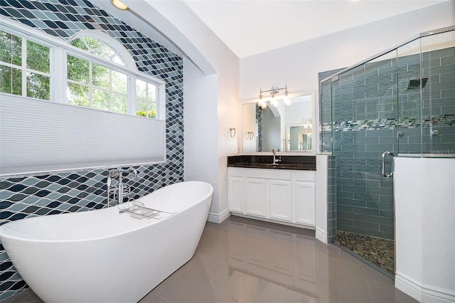 2258 Rickover Pl, Winter Garden, FL 34787 - bathroom featuring vanity, a freestanding bath, a stall shower, tile patterned flooring, and tile walls