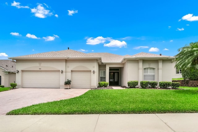 785 Hawks Blf, Clermont, FL 34711 - view of front of house featuring a garage, stucco siding, driveway, and a front yard