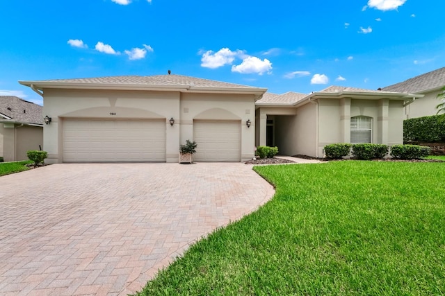 785 Hawks Blf, Clermont, FL 34711 - view of front of house featuring decorative driveway, a garage, stucco siding, and a front lawn
