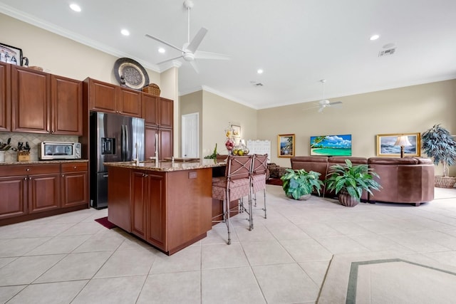 785 Hawks Blf, Clermont, FL 34711 - kitchen featuring a ceiling fan, stainless steel appliances, ornamental molding, a kitchen breakfast bar, and light stone countertops