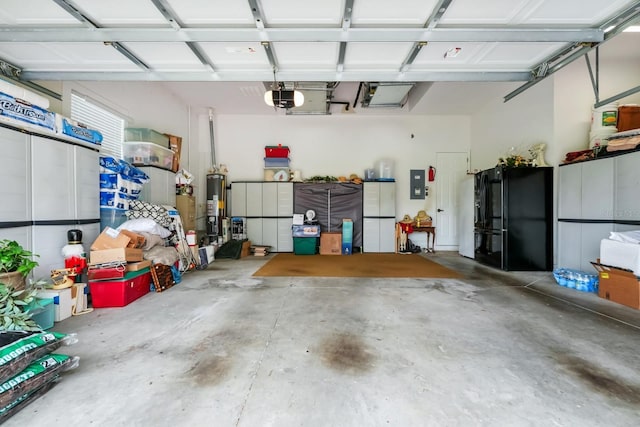 785 Hawks Blf, Clermont, FL 34711 - garage with freestanding refrigerator, gas water heater, and a garage door opener