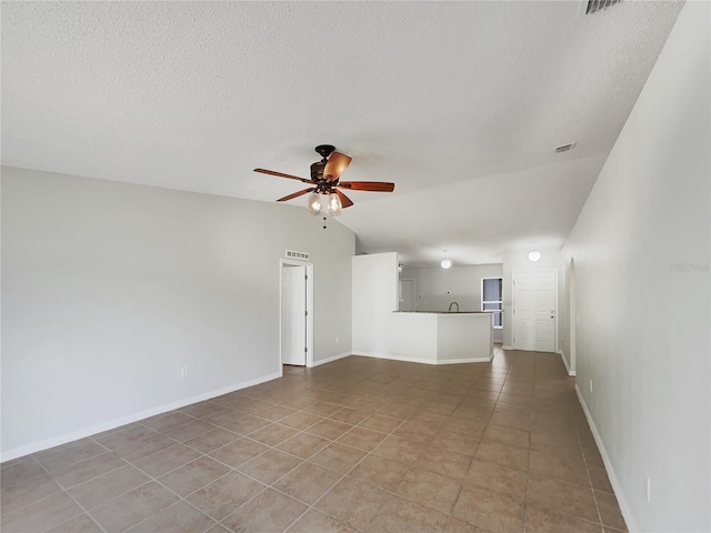 1726 Sunset Ridge Dr, Mascotte, FL 34753 - unfurnished living room featuring ceiling fan, vaulted ceiling, a textured ceiling, and tile patterned floors