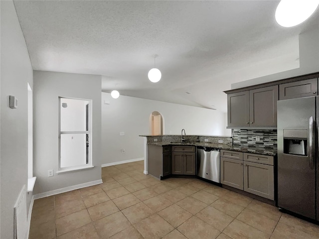 1726 Sunset Ridge Dr, Mascotte, FL 34753 - kitchen featuring stainless steel appliances, a peninsula, backsplash, vaulted ceiling, and light tile patterned floors
