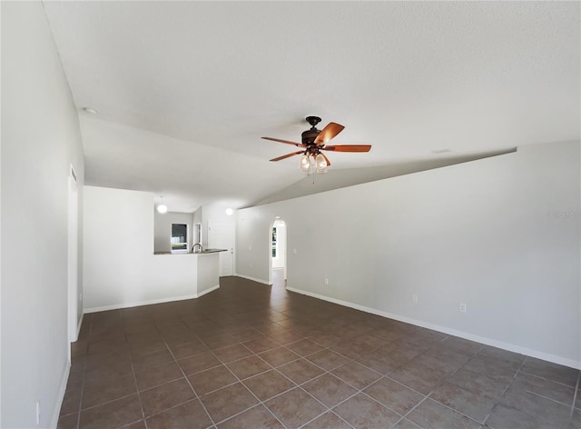 1726 Sunset Ridge Dr, Mascotte, FL 34753 - unfurnished living room with a ceiling fan, vaulted ceiling, dark tile patterned flooring, and arched walkways