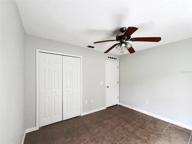 1726 Sunset Ridge Dr, Mascotte, FL 34753 - unfurnished bedroom featuring dark tile patterned floors, a closet, ceiling fan, and a textured ceiling