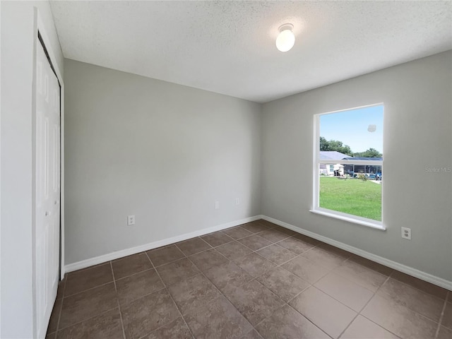 1726 Sunset Ridge Dr, Mascotte, FL 34753 - unfurnished bedroom with a textured ceiling, a closet, and dark tile patterned floors