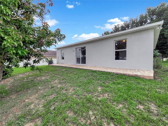 1726 Sunset Ridge Dr, Mascotte, FL 34753 - rear view of house featuring stucco siding, a patio area, and a yard