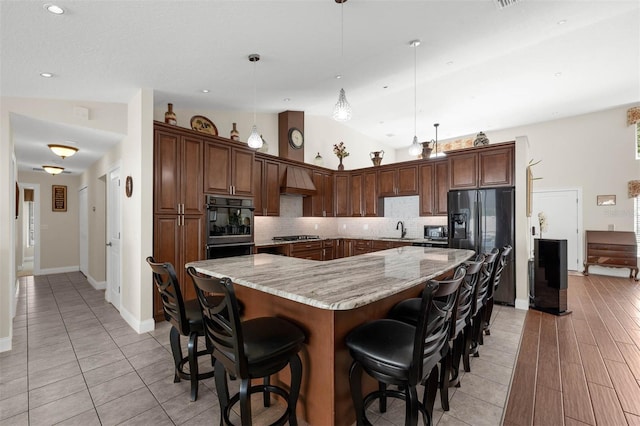 9342 Bay Vista Estates Blvd, Orlando, FL 32836 - kitchen with decorative backsplash, light stone counters, fridge with ice dispenser, a breakfast bar, and a large island