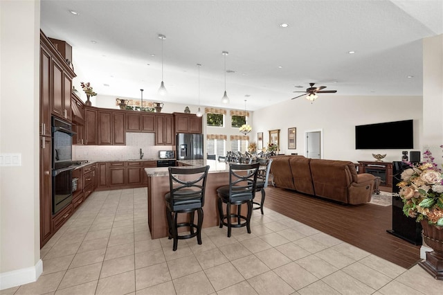 9342 Bay Vista Estates Blvd, Orlando, FL 32836 - kitchen featuring appliances with stainless steel finishes, open floor plan, a kitchen bar, hanging light fixtures, and a ceiling fan