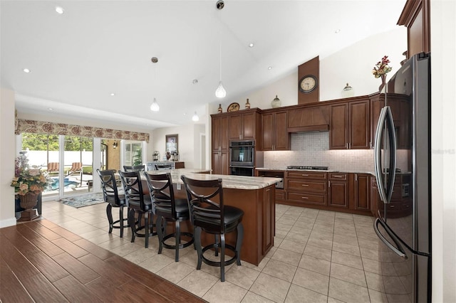9342 Bay Vista Estates Blvd, Orlando, FL 32836 - kitchen featuring appliances with stainless steel finishes, decorative backsplash, a kitchen island, a kitchen breakfast bar, and vaulted ceiling
