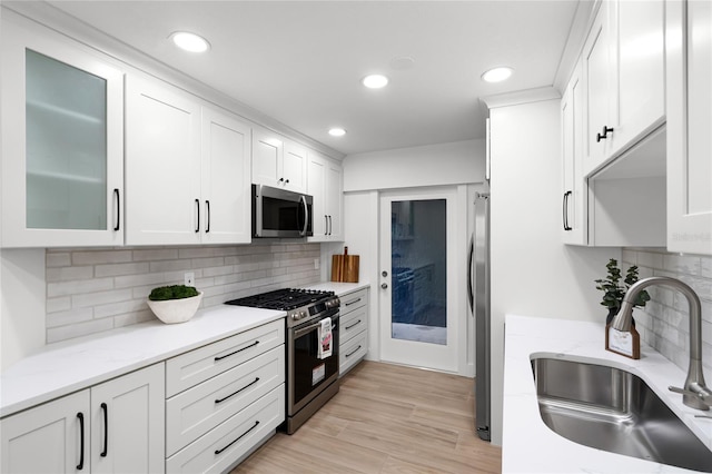 610 Huntly Ln, Winter Springs, FL 32708 - kitchen with appliances with stainless steel finishes, white cabinets, recessed lighting, tasteful backsplash, and glass insert cabinets