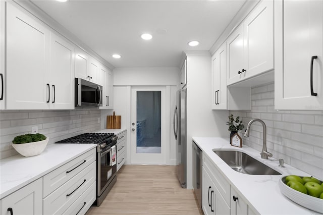 610 Huntly Ln, Winter Springs, FL 32708 - kitchen with stainless steel appliances, recessed lighting, white cabinetry, decorative backsplash, and light wood-style flooring