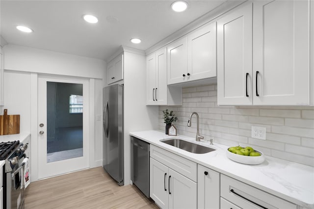 610 Huntly Ln, Winter Springs, FL 32708 - kitchen featuring appliances with stainless steel finishes, white cabinetry, decorative backsplash, light wood-style floors, and recessed lighting
