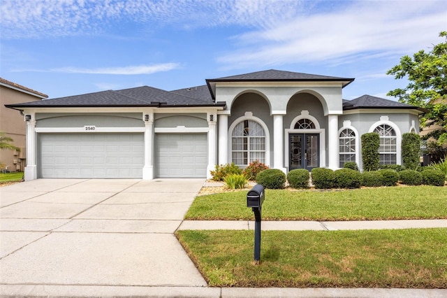 2540 Wembleycross Way, Orlando, FL 32828 - view of front of house with an attached garage, driveway, a front lawn, stucco siding, and french doors
