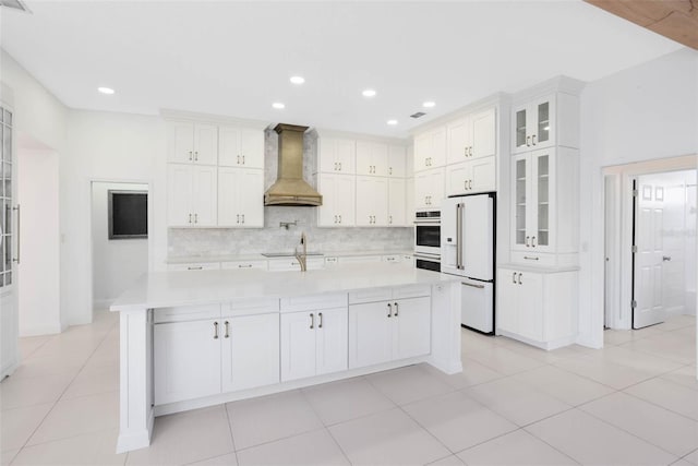 2540 Wembleycross Way, Orlando, FL 32828 - kitchen featuring premium range hood, high end white refrigerator, light countertops, tasteful backsplash, and recessed lighting