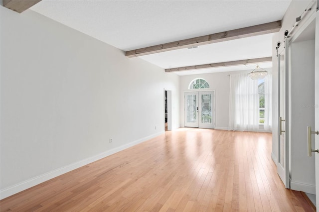 2540 Wembleycross Way, Orlando, FL 32828 - spare room with a barn door, beamed ceiling, and light wood finished floors