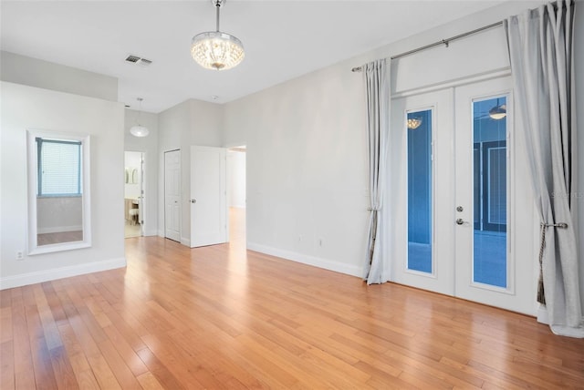 2540 Wembleycross Way, Orlando, FL 32828 - empty room featuring light wood finished floors, french doors, and a chandelier