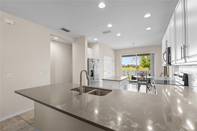 3443 Sagebrush St, Harmony, FL 34773 - kitchen featuring appliances with stainless steel finishes, a center island, recessed lighting, white cabinets, and a peninsula