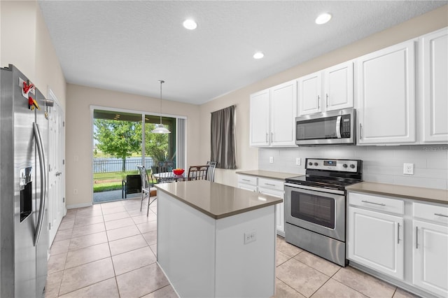 3443 Sagebrush St, Harmony, FL 34773 - kitchen featuring appliances with stainless steel finishes, a kitchen island, white cabinetry, tasteful backsplash, and recessed lighting