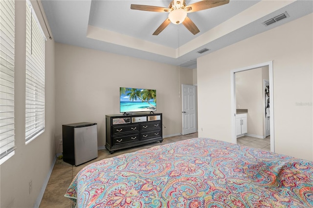 3443 Sagebrush St, Harmony, FL 34773 - bedroom featuring freestanding refrigerator, multiple windows, light tile patterned flooring, and a tray ceiling