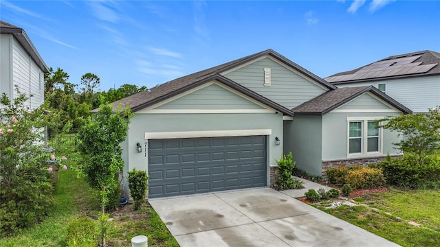 711 Steerview St, Saint Cloud, FL 34771 - traditional-style house featuring driveway, a garage, stone siding, and stucco siding