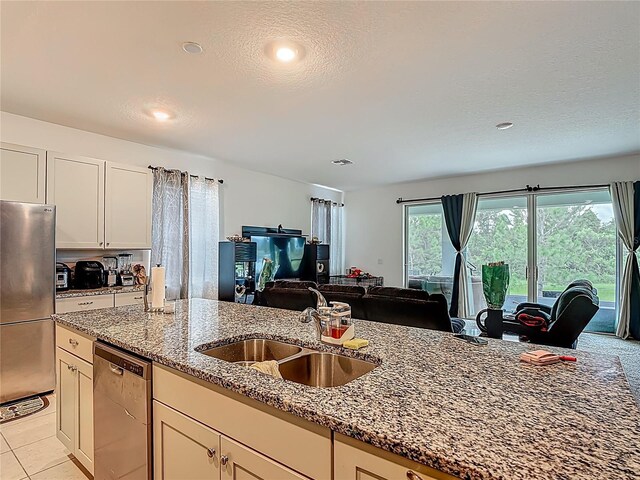 711 Steerview St, Saint Cloud, FL 34771 - kitchen featuring appliances with stainless steel finishes, open floor plan, stone countertops, recessed lighting, and white cabinets