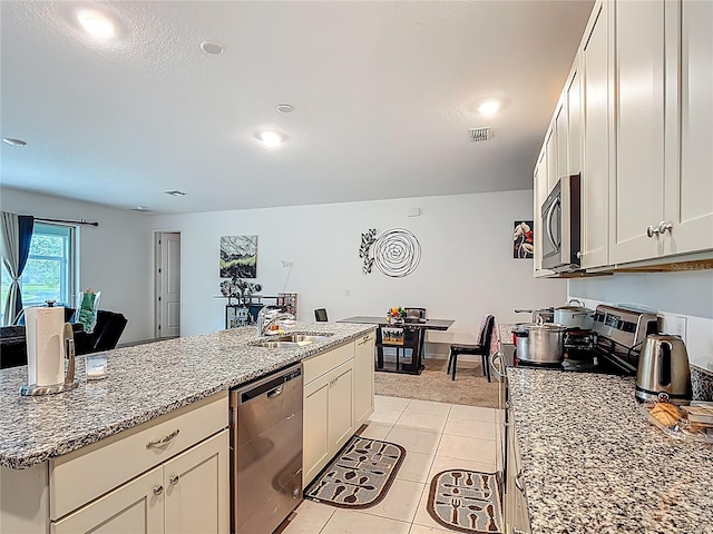711 Steerview St, Saint Cloud, FL 34771 - kitchen with stainless steel appliances, light stone counters, light tile patterned flooring, white cabinets, and recessed lighting