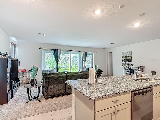 711 Steerview St, Saint Cloud, FL 34771 - kitchen with dishwashing machine, open floor plan, light stone counters, light tile patterned flooring, and white cabinetry