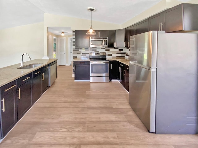 4233 Las Vegas Dr, New Port Richey, FL 34653 - kitchen featuring stainless steel appliances, lofted ceiling, light wood-style flooring, light stone countertops, and hanging light fixtures
