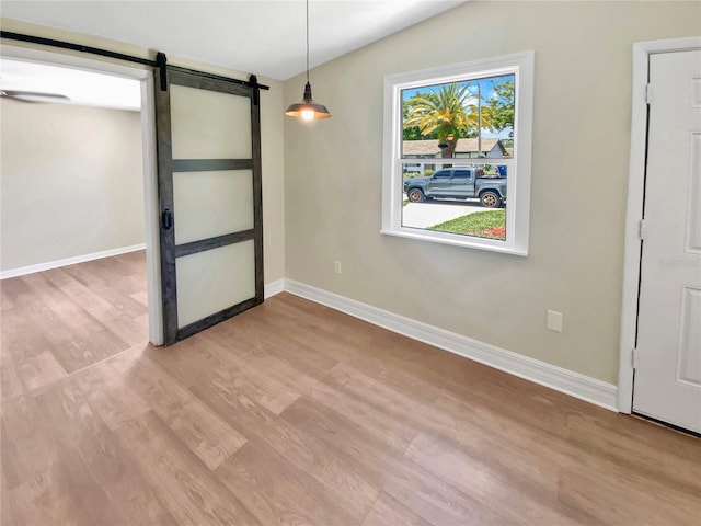 4233 Las Vegas Dr, New Port Richey, FL 34653 - unfurnished dining area featuring a barn door, vaulted ceiling, and light wood-style floors