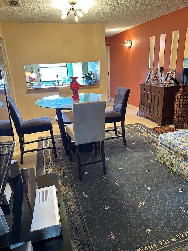 3279 Westridge Blvd Unit 204, Orlando, FL 32822 - dining room featuring a textured ceiling and a chandelier