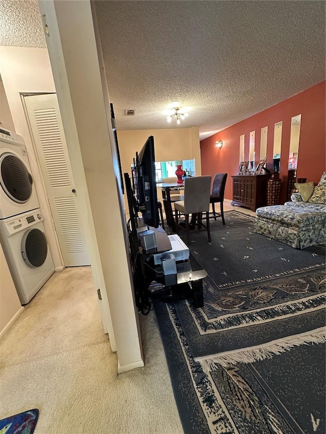 3279 Westridge Blvd Unit 204, Orlando, FL 32822 - living room with stacked washer / drying machine, light colored carpet, and a textured ceiling