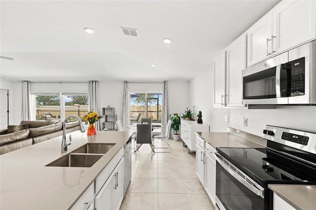 1291 Lassen St, Haines City, FL 33844 - kitchen with appliances with stainless steel finishes, open floor plan, white cabinetry, and recessed lighting