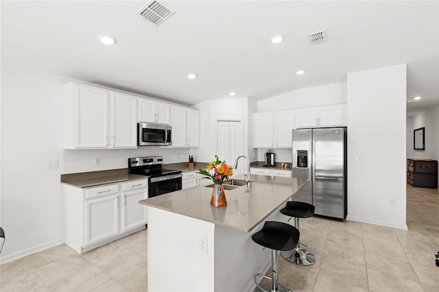 1291 Lassen St, Haines City, FL 33844 - kitchen with stainless steel appliances, a kitchen bar, white cabinetry, recessed lighting, and a kitchen island with sink
