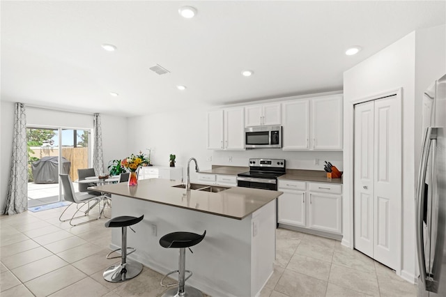 1291 Lassen St, Haines City, FL 33844 - kitchen featuring appliances with stainless steel finishes, a kitchen breakfast bar, white cabinets, an island with sink, and recessed lighting