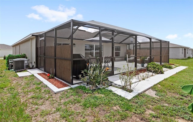 1291 Lassen St, Haines City, FL 33844 - rear view of property featuring a patio, glass enclosure, and a yard