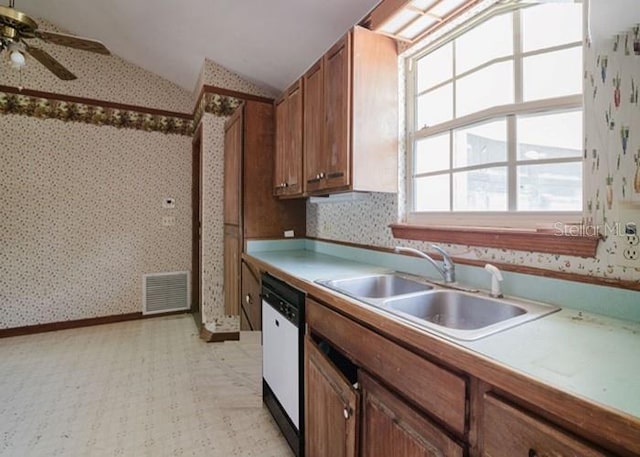 6140 SE 46th Avenue Rd, Ocala, FL 34480 - kitchen with wallpapered walls, white dishwasher, lofted ceiling, brown cabinetry, and ceiling fan