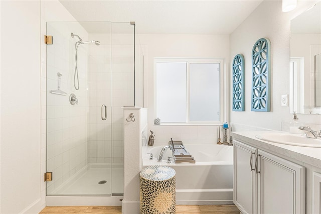 1668 Wilson Prairie Cir, Groveland, FL 34736 - bathroom with vanity, a stall shower, a garden tub, and wood finished floors