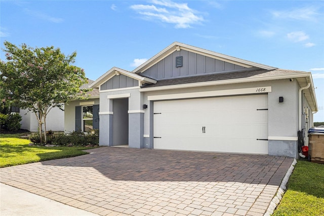 1668 Wilson Prairie Cir, Groveland, FL 34736 - view of front facade featuring board and batten siding, decorative driveway, a garage, stucco siding, and a front lawn