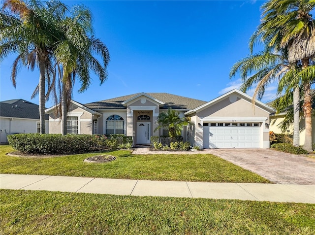 429 Belfry Dr, Davenport, FL 33897 - ranch-style home with stucco siding, an attached garage, a front lawn, and driveway