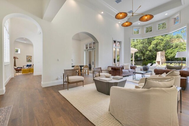 6186 Louise Cove Dr, Windermere, FL 34786 - living area featuring arched walkways, a towering ceiling, dark wood-style floors, recessed lighting, and plenty of natural light