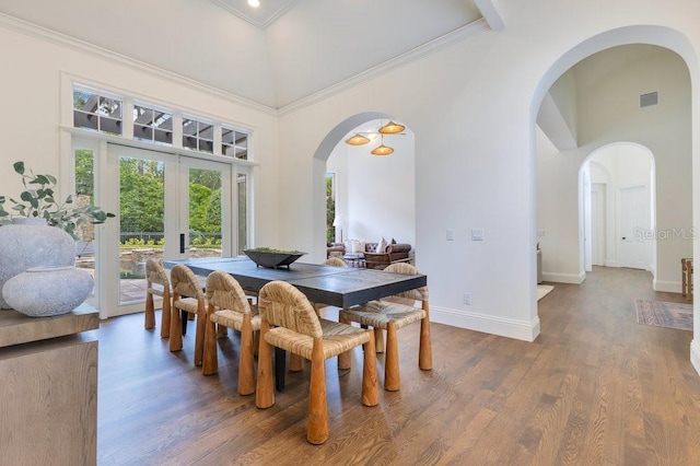 6186 Louise Cove Dr, Windermere, FL 34786 - dining space with arched walkways, a high ceiling, wood finished floors, ornamental molding, and french doors