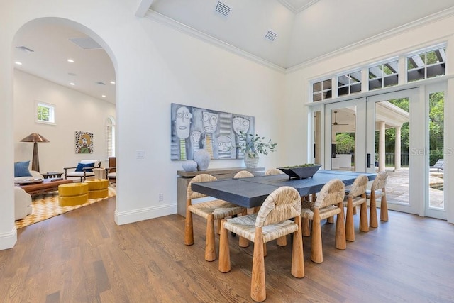 6186 Louise Cove Dr, Windermere, FL 34786 - dining area with arched walkways, wood finished floors, a high ceiling, french doors, and crown molding